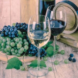 Weißwein und Rotwein mit Weintrauben auf einem Holztisch